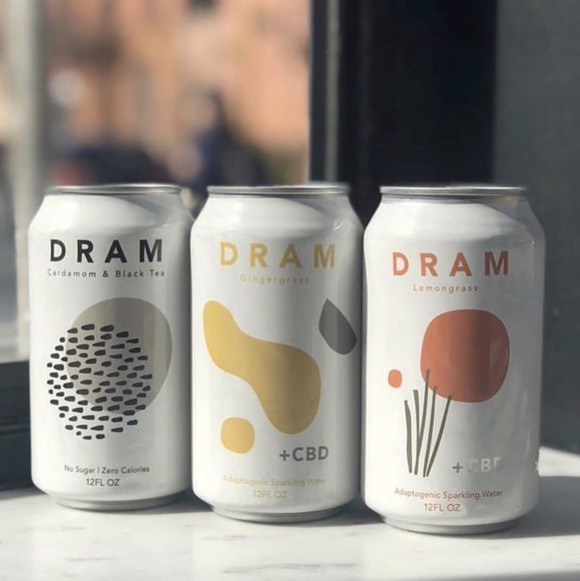 3 cans of Dram Sparkling Water with shrink sleeves custom labels.