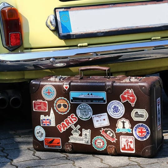 suitcase with many stickers and labels