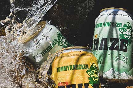 Three cans of TommyKnocker craft beer in a ice cold stream.
