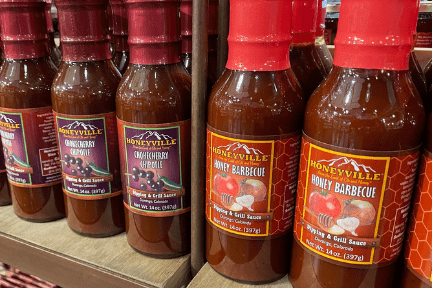 With attractive labels, Honeyville's Chokecherry and Honey Barbecue Sauces sit on a store shelf awaiting their new owners.