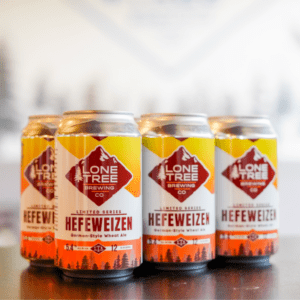 Four custom-branded cans of Lone Tree Hefeweizen beer.
